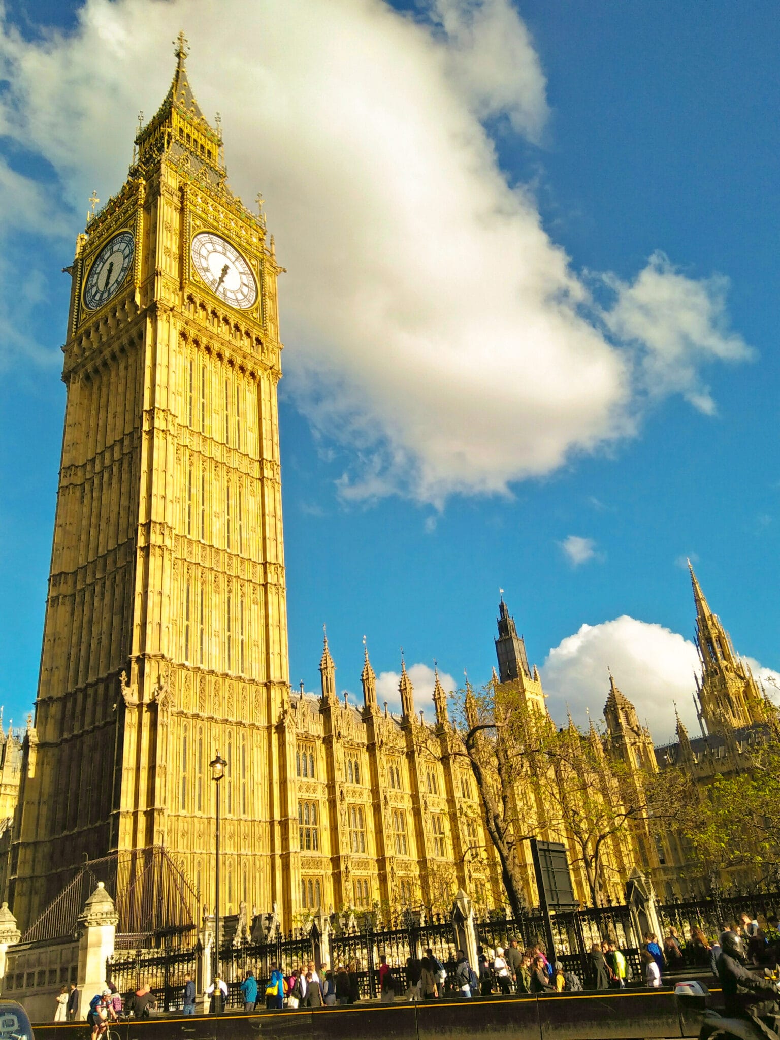 The Big Ben and the Palace of Westminster shining like a golden building as the sunlight hits it.