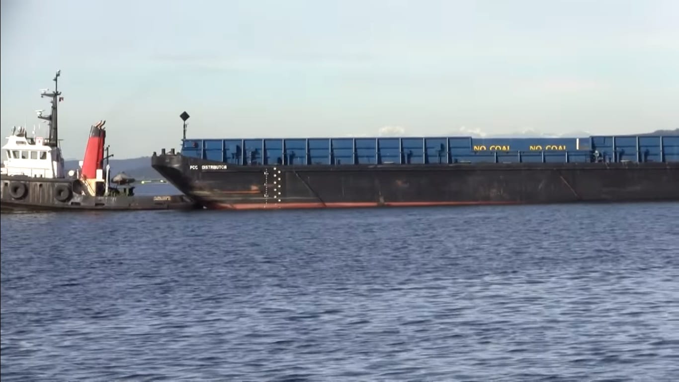 Harbor tug towing dumb barge