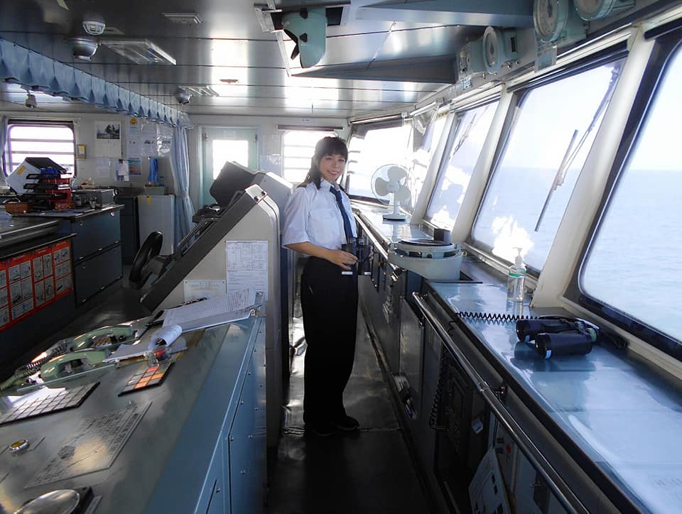 Female second officer Hiroka Suzuki wearing her marine uniform while on duty inside the bridge.