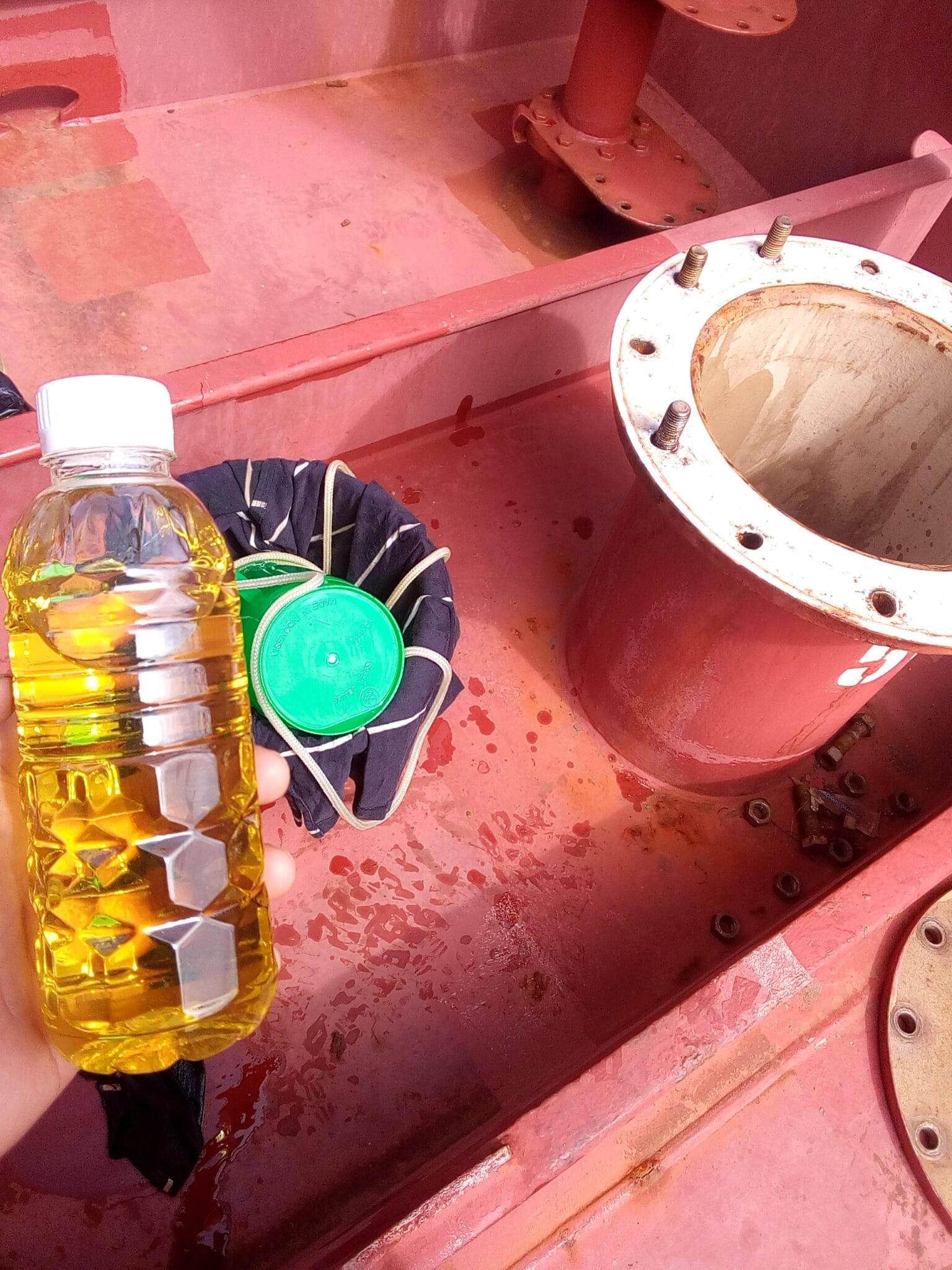 Holding a bottle of vegetable oil taken after open sampling method using the Butterworth Hole of a tanker vessel.