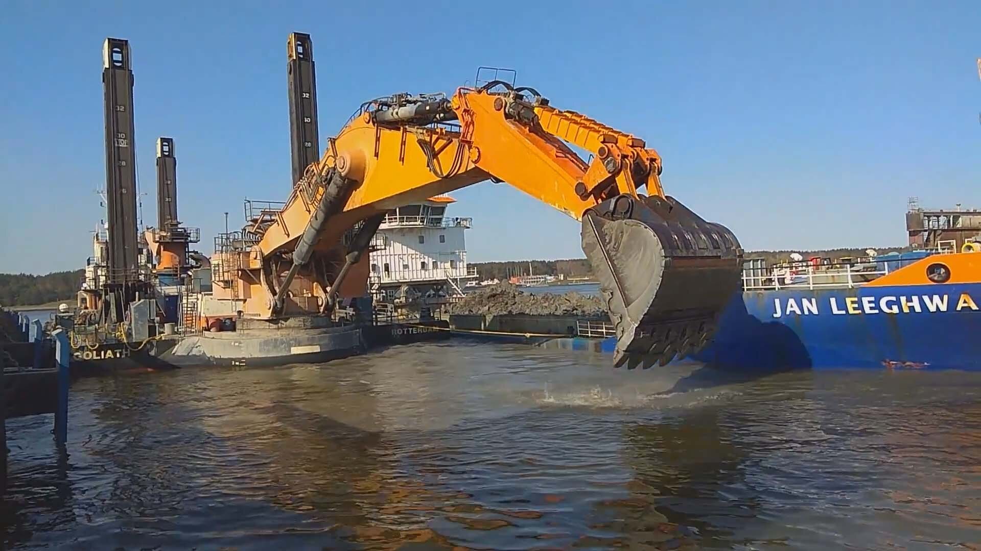 Van Oord's huge Back Hoe Dredger named Goliath dredging a part of the port alongside a hopper barge.