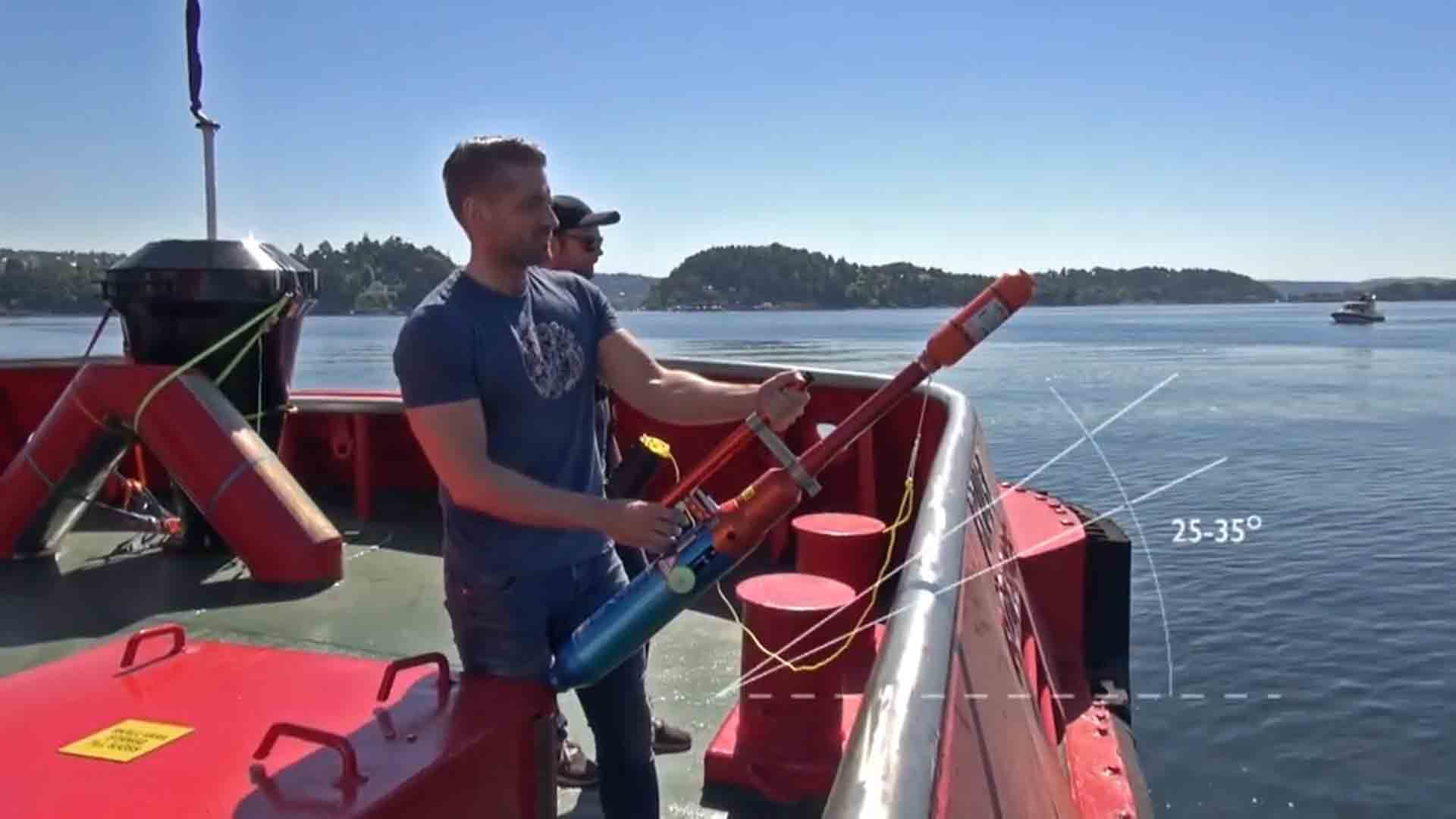 Two persons using a pneumatic line-thrower. One guy holds the main body unit while the other one holds the rope container.