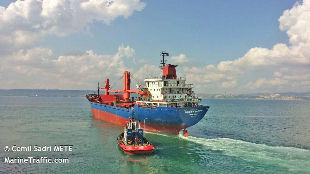 Cargo ship Rusen Mete escorted by a tugboat.