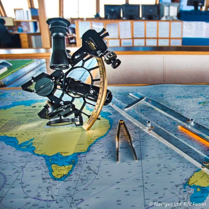 https://www.instagram.com/rv_petrel/ A marine sextant beside a compass divider and parallel rulers on top of a nautical chart.