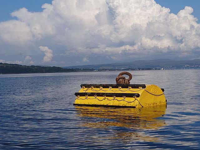 A mooring buoy shaped like a barrel having yellow and black color.