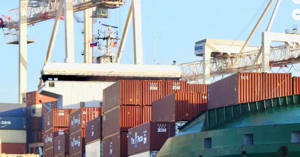 Container ship with various flags including the yellow Quarantine or Quebec Flag.