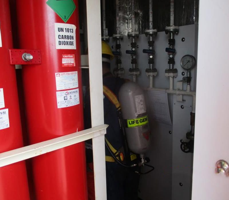 Crew entering CO2 Room with huge red Carbon Dioxide bottles.