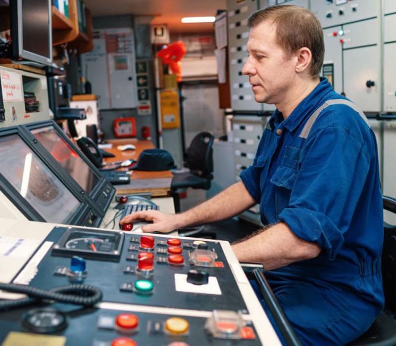 A Second Engineer checking machinery status in the computer inside the Engine Control Room.