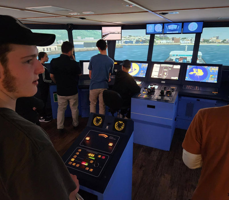 Young Australian students performing full navigation simulator.